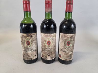three bottles of red wine sit on a white surface