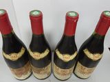 four bottles of wine are lined up on a table