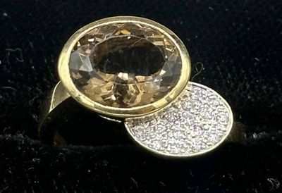 yellow gold ring with a faceted smokyite surrounded by white diamonds