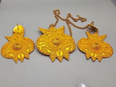 Trois bijoux en or sont posés sur une table