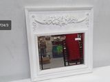 a mirror sitting on a white table in front of a red chair
