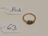 deux pendentifs, l'un avec une bague en or et l'autre avec une bague en diamant, posés sur une surface blanche