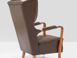 the back of a brown leather chair with a wooden frame
