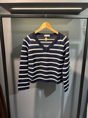un pull rayé bleu marine et blanc suspendu à un cintre dans une armoire