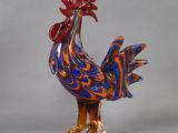 a glass rooster that is standing on a base