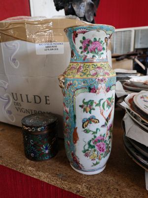 un grand vase posé sur un comptoir, à côté d'une pile d'assiettes