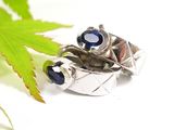 a silver ring with a blue stone on top of a leaf