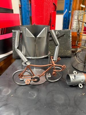 une sculpture métallique représentant un homme à vélo à côté d'un lampadaire