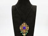 un collier orné d'une fleur violette et de perles vertes, porté par un mannequin noir