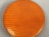 an image of a round orange purse sitting on top of a table