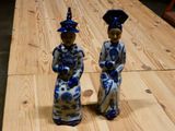 pair of blue and white figurines sitting on a wooden table