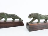 these are two figurines of a lion and a tiger on a wooden base