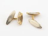 une paire de boutons de manchette en or et en argent sur fond blanc
