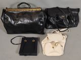 deux sacs à main noirs et blancs et un sac à main noir posés sur une table
