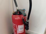 a red fire extinguisor next to a white wall