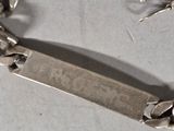 a silver bracelet that has a bar on it