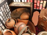 a basket full of clay pots and bowls and a container of eggs