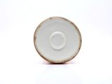 a white plate with a brown rim on a white surface