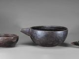 two cups and a teapot sit on a table next to each other