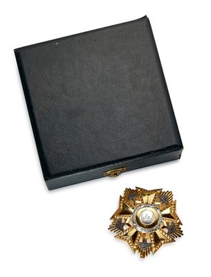 boîte noire ornée d'une broche dorée et blanche et d'une épingle à broche dorée