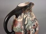 a ceramic pitcher with a painting on it sitting on a table