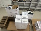 Plusieurs cartons de vin sont empilés les uns sur les autres dans une pièce