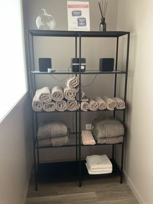 Des serviettes sont empilées sur une étagère dans une salle de bains dotée d'une fenêtre
