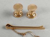 a close up of a pair of gold earrings and a pair of scissors