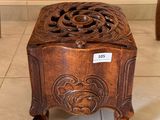 une petite boîte en bois posée par terre, sur laquelle est accrochée une étiquette de prix