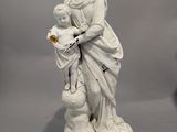 une statue représentant une femme tenant un enfant sur ses genoux