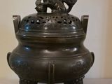 une image représentant un brûle-parfum en bronze surmonté d'un oiseau