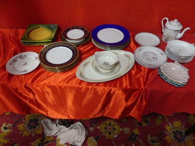 many plates and cups on a table with a red table cloth