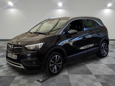 a black car parked on a checkered floor in a garage