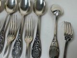 a lot of silver spoons and forks on the table