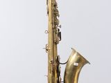 an old brass saxophone sitting on top of a wooden stand