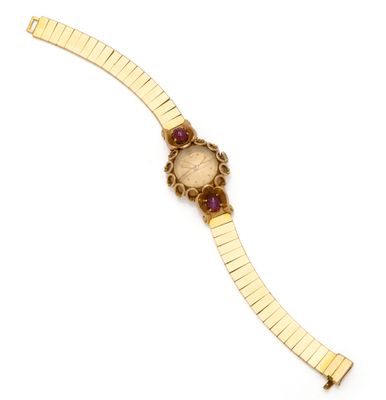 a close up of a gold wrist watch with a red face