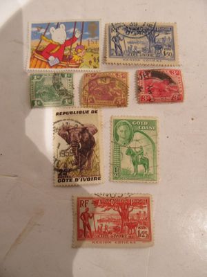 several different types of stamps on a table with a shadow of a person