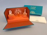 une boîte ouverte contenant trois flacons de parfum et une carte