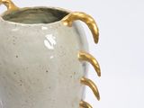a white vase with gold spikes on it