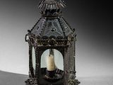 pair of antique metal lanterns with candle holders on a white surface
