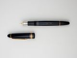 a close up of a fountain and a pen on a white surface
