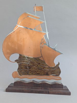 une sculpture représentant un bateau, posée sur un socle en bois