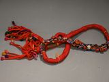 a red rope with a knot on it on a table