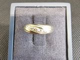 une alliance en or jaune sertie de diamants, présentée dans un coffret cadeau posé sur une table