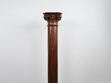 une colonne ancienne en bois se dresse sur un parquet en bois massif