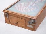a small wooden box with a glass top on a white surface