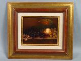 tableau représentant une nature morte composée de fruits et de noix, dans un cadre doré