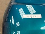 a close up of a blue car with a sticker on it ' s hood