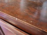 a close up of a wooden table with a cup on it