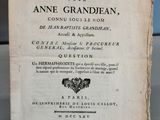 un vieux livre posé sur une table à côté d'un mur bleu